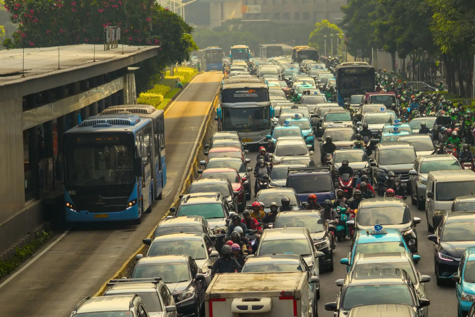 Dense traffic of cars, buses and motorbikes on a city street